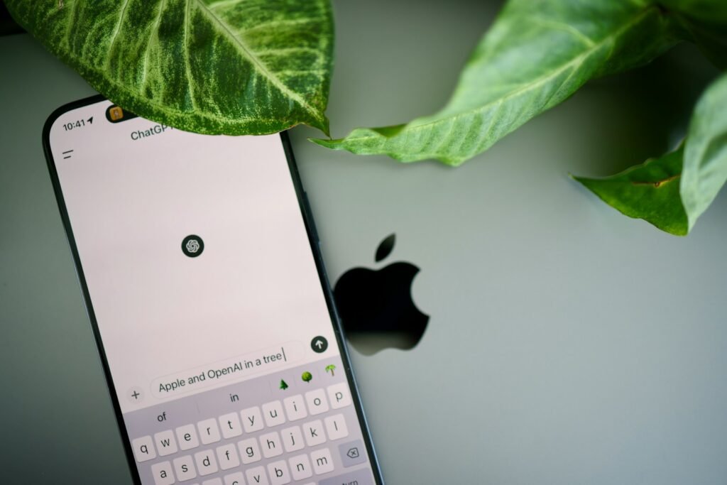 a cell phone sitting next to a green leaf