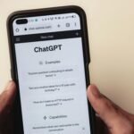 Webpage of ChatGPT, a prototype AI chatbot, is seen on the website of OpenAI, on a smartphone. Examples, capabilities, and limitations are shown.